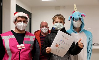 Mika Delius (11) aus Herford präsentiert stolz seine Impf-Urkunde. Nikolaus Marco Halbert, Papa Jens Delius und Einhorn Fabian Weßler freuen sich mit ihm. - Frank-Michael Kiel-Steinkamp