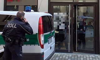 Ein telefonierender Zoll-Beamter vor einem der Herforder Nagelstudios. - Jobst Lüdeking