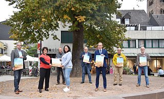 Stefan Fellmann (Stadt Höxter, v. l.), Claudia Koch (Landesgartenschau-Geschäftsführerin), Thomas Schöning (Förderverein), Ulrike Drees (Förderverein), Volker Rodermund (Stadt Höxter), Bürgermeister Alexander Fischer, Ralf Haffke (Stadt Höxter) und Holger Sielemann (Förderverein) freuen sich auf den Infomarkt in Höxter. - LGS
