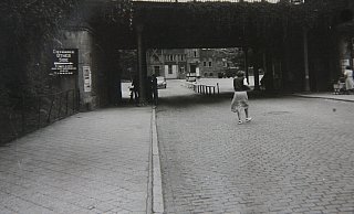 Kontrolle: Der Checkpoint an der Bahn-Unterführung Herforder Straße/Ecke Kaiserstraße war einer der Hauptzugangspunkte zur gesperrten Innenstadt. Während eine Fußgängerin die Straße kreuzt, rollt im Hintergrund ein VW Käfer heran. - Foto: Stadtarchiv