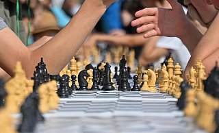 Spieler vertieft in eine spannende Schachpartie beim Freiluftturnier: Testen Sie Ihr Wissen mit unserem Quiz! - picture alliance/dpa