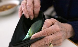 Eine ältere Frau öffnet ihr Portemonnaie. (Archivbild) - Stephanie Pilick/dpa