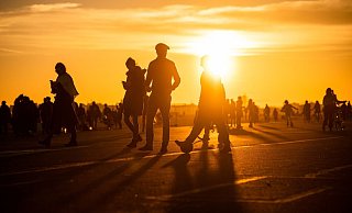 Menschen spazieren während des Sonnenuntergangs bei frühlingshaften Temperaturen auf dem Tempelhofer Feld in Berlin. - Foto: Christophe Gateau/dpa