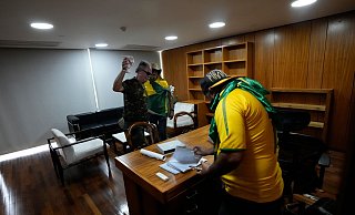 Bolsonaro-Anhänger wühlen sich in einem Büro des Palacio do Planalto, dem offiziellen Sitz des brasilianischen Präsidenten, durch Papiere. - Eraldo Peres/AP/dpa