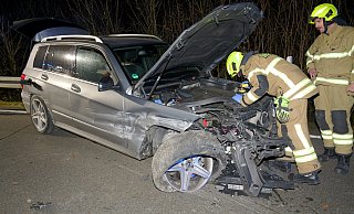 Feuerwehrleute kümmern sich um das Batteriemanagement des unfalbeschädigten Mercedes im Auffahrtsbereich zur B1 an der Dubelohstraße - Ralph Meyer