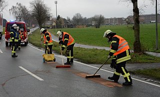 Die Feuerwehr brachte das Ölbindemittel wie hier auf der Sürenheider Straße mit einem Streuer auf der Fahrbahn aus und arbeitete es mit Handbesen ein. - Andreas Eickhoff
