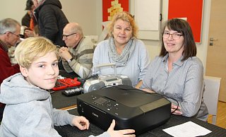 Der 14-jährige Tamilo Palm ist der jüngste Experte. Er schaut sich den CD-Player von Birgit Rohling und den Drucker von Manuela Fortmeier an (v.l.). - Regina Brucksch
