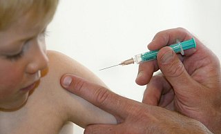 Ein Kinderarzt impft einen kleinen Jungen. - picture alliance / Karl-Josef Hildenbrand/dpa
