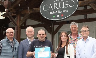 Ortsheimatpfleger Uwe Lomberg, Bürgermeister Henning Vieker, Investorin Saskia Thomas, Jan-Dirk Jungvogel und Ortsvorsteher Max Grote (v. l.) wünschen dem neuen Gastwirt Stefano Martina gutes Gelingen. Stefano Martina hält das Geschenk der Stadt, das Espelkamper Jubiläumsbuch, in seinen Händen. - Klaus Frensing