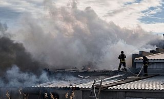 Feuerwehrleute des staatlichen ukrainischen Katastrophenschutzes löschen ein Feuer, das nach Beschuss eines Industriegebiets in Cherson ausgebrochen ist. - Libkos/AP/dpa
