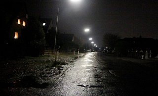 Die Alte Werster Straße: Pfützen, glänzender Asphalt, grelles Laternenlicht - und hier und da ein Leuchten im Fenster. - Meiko Haselhorst