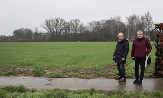 Hans-Ulrich Hart und Rita Austmeyer von der Bürgerinitiative Elverdissen stehen an der noch ganz unbebauten Fläche an der früheren Hauptschule (Hintergrund). Sie sind gegen dreieinhalbgeschossige Mehrfamilienhäuser und wünschen sie erst recht nicht an einer Stelle konzentriert. - Frank-Michael Kiel-Steinkamp