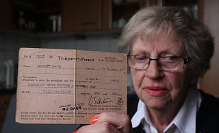 Dokument: Die heute 77 Jahre alte Gisela Jacke zeigt den Passierschein aus dem Jahr 1951. - Foto: Nicole Sielermann