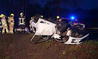Der zerstörte VW Golf bleibt auf dem Dach liegen. Einsatzkräfte der Feuerwehr Delbrück retten den schwer verletzten Fahrer aus dem Wrack. - Ralph Meyer