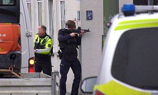Dieses Bild kursiert in sozialen Medien: Der Polizist zielt um die Ecke, jedoch fehlt das Magazin seiner Waffe. Dafür gibt es jedoch eine Erklärung. - Christian Müller/TV7news/dpa