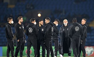 Die DFB-Spieler stehen vor dem Aufwärmen auf dem Rasen. - Foto: Christian Charisius/dpa