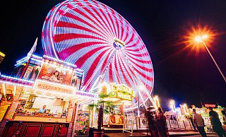 Das Riesenrad – mit 26 Gondeln und einer Höhe von 38 Metern – leuchtet abends in den buntesten Farben. - Besim Mazhiqi