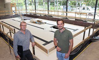 Valeri Lehn (l.) und Tobias Bollmann vor dem neuen Löhner Schwimmbecken. Der neue Hubboden ist bereits installiert. - Dirk Windmöller