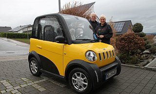 Inge und Jürgen Helmert mit ihrem chinesischen Elektroauto. Auf dem Fahrersitz hat Hund Tuula Platz genommen. - Nicole Bliesener