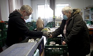 Helfer Günter Niemann gibt Lebensmittel an Sylvia Lehmann aus. - Felix Eisele