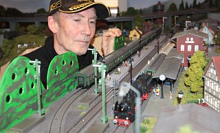 Friedel Weber beobachtet genau, wie die Züge am Bürener Bahnhof vorbeifahren. Mit viel Liebe zum Detail hat er seine Anlage gestaltet. - Uwe Müller