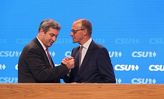 CSU-Chef Markus Söder steht mit Friedrich Merz,Vorsitzender der CDU, nach dessen Rede auf der Bühne. - Karl-Josef Hildenbrand/dpa