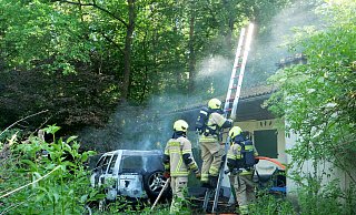 Unter Atemschutz löschten die Einsatzkräfte einen brennenden Land Rover auf dem Gelände eines Ferienhauses am Scharmeder Stadtweg. - Ralph Meyer