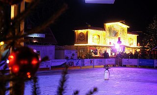 Ein einsamer Pinguin steht auf der Plastikeisbahn des Weihnachtsmarktes und wartet auf Kinder. - THORSTEN ULONSKA
