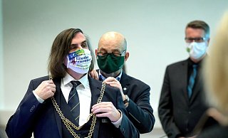 Viermal hat er für diesen Moment kandidiert: Norbert Morkes (69) darf seit gestern die Bürgermeisterkette der Stadt Gütersloh tragen. Fachbereichsleiter Rainer Spies legt sie ihm an. Morkes wählte zu diesem Anlass eine Maske mit „Gütersloh International". - Andreas Frücht