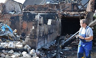 Thomas Möller von der Kriminalpolizei Minden untersucht die Brandruine an der Lübbecker Straße. Mit der Kamera hält er den entstandenen Schaden fest. - Doris Christoph