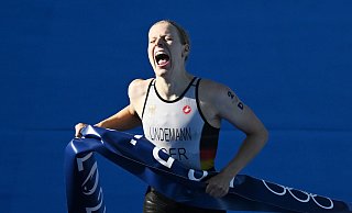 Laura Lindemann trägt bei der Schlussfeier der Olympischen Spiele gemeinsam mit Max Rendschmidt die deutsche Fahne. - Marijan Murat/dpa