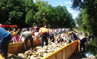 Bielefelder Feuerwehrleute und Johanniter sowie zahlreiche Schönebecker packen so viele Sandsäcke wie möglich. Mit Schubkarren werden sie anschließend an die durchgeweichten Deiche geschafft. - FOTO: JOHANNITER