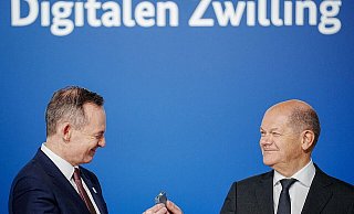 Bundeskanzler Olaf Scholz (r, SPD) übergibt an Volker Wissing (FDP), Bundesminister für Verkehr und Digitales, eine Komponente eines Schaltschranks weiter. - Kay Nietfeld/dpa