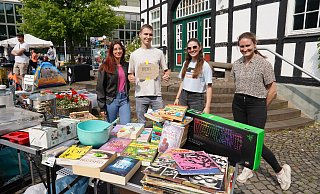 Sofia (v.l.), Max, Grace und Zara haben Bücher und Klamotten zum Flohmarkt in der Bünder Innenstadt mitgebracht. Dass auch per PayPal bezahlt werden kann macht Max auf seinem T-Shirt deutlich. - Yvonne Gottschlich