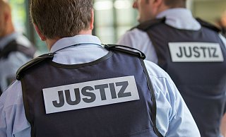 Justizbeamte sind vor einem Sitzungssaal im Landgericht Bielefeld zu sehen. Unter verstärkten Sicherheitsvorkehrungen beginnt am Freitag der Prozess im Fall Nimani- - dpa