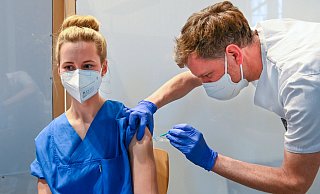 Krankenpfleger Rainer Kleßmann injiziert Vanessa Bahra, die auf der Covid-Intensivstation des EvKB arbeitet, den Impfstoff. - Bethel/ Christian Weische