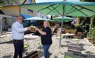 Karl-Heinz Bauer und Andrea Höner zu Siederdessen freuen sich, dass die Menschen bei ihnen im Biergarten des Jägerkrug wieder anstoßen können. - Frank-Michael Kiel-Steinkamp