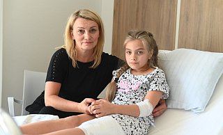 Nach den Bissen eines nicht angeleinten Hundes sitzt die zehnjährige Wiktoria mit dickem Verband am Oberschenkel im Krankenbett. Ihre Tante Danuta Kaiser hält ihre Hand und tröstet das Kind. Ein paar Tage muss das Mädchen noch im Krankenhaus bleiben. - EvKB