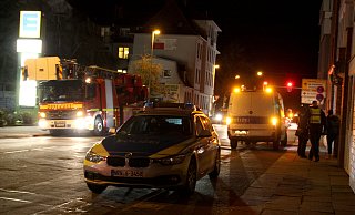 Polizisten führen eine junge Frau aus dem Haus und bringen die Festgenommene mit dem Gefangenentransporter auf die Wache. Die Drehleiter steht schon bereit. - Jens Reichenbach