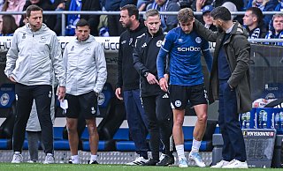 Schalkes Coach Miron Muslic (r.) wünscht Jonny Grodowski gute Besserung. Trainer Mitch Kniat (3. v.l.) und der vierte Offizielle Felix Weller (4. v.l.) hatten den Stürmer aus der Partie genommen. - KROEGER/RHR-FOTO