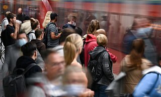 Fahrgäste warten an einem Gleis im Tiefbahnhof des Frankfurter Hauptbahnhofs, während eine S-Bahn einfährt. - Arne Dedert/dpa