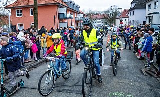 Schulkinder und Erwachsene treten im "Fahrradbus" kräftig in die Pedale. Sie werden an der Sudbrackschule begeistert empfangen. - Barbara Franke