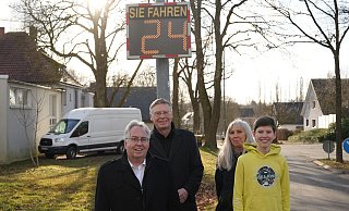 Der 14-Jährige Julian Arndt freut sich, dass sich sein Einsatz für ein Geschwindigkeitsdisplay und einen mobilen Blitzer an der Milchstraße gelohnt haben. Das sehen auch Landrat Jürgen Müller (links), Bürgermeister AndreasHüffmann und die Großmutter Gaby Arndt so. - Kreis Herford