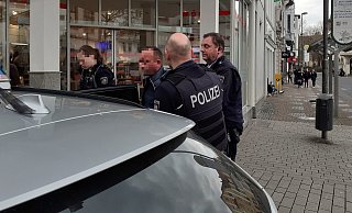 Drei Beamte haben den Festgenommenen zum Streifenwagen gebracht. - Jobst Lüdeking