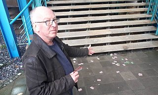 Schöffe Günter Pähler zeigt auf einige der Flyer, die im Eingangsbereich des Landgerichts liegen. Sie sind auch auf sowie unter der Treppe zu finden. - Ingo Kalischek