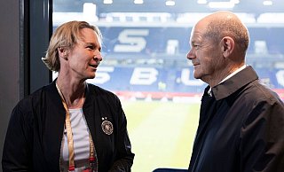 Bundeskanzler Olaf Scholz spricht mit Martina Voss-Tecklenburg, Trainerin der deutschen Frauen-Nationalmannschaft. - Thomas Boecker/DFB/dpa