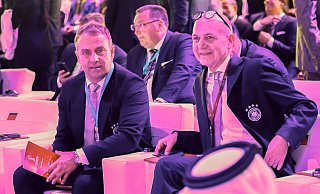 Nationaltrainer Hansi Flick (l) und DFB-Präsident Bernd Neuendorf sitzen bei der Vorrunden-Auslosung zusammen. - Christian Charisius/dpa