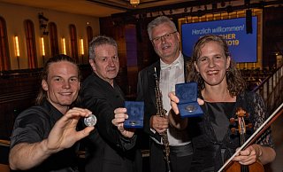 Geehrt: Schauspieler Jan Hille (v. l.) und Generalmusikdirektor Alexander Kalajdzic, Konzertmeisterin Katrin Adelmann und Klaus-Joachim Dudler (Oboe). Die drei Musiker nehmen den Operntaler stellvertretend für die Bielefelder Philharmoniker entgegen. - DENNIS ANGENENDT