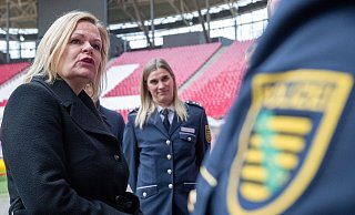 Nancy Faeser (SPD, l), Bundesinnenministerin, unterhält sich in der Leipziger Arena mit Vertretern der Polizei. - Hendrik Schmidt/dpa