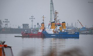 Das Mehrzweckschiff «Odin» fährt mit einem Ponton über das Wasser vor der Schleuse, um das Öl aufzunehmen. - Jonas Walzberg/dpa